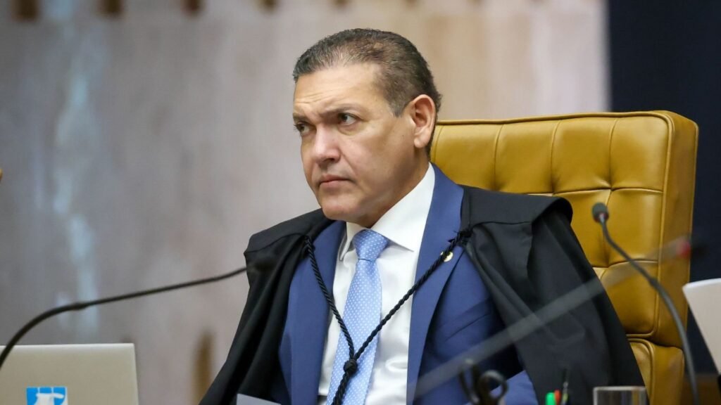 Ao centro, ministro Kassio Nunes Marques com terno e toga, sentado em cadeira do STF.